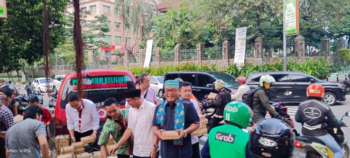 Ketua Ikadin Jakarta Selatan Bontor OL Tobing dan Wakilnya Riesky Indrawan beserta anggota Ikadin membagikan nasi kotak kepada pengendara di depan Kantor Walikota Jakarta Selatan, Selasa (18/4/2023).