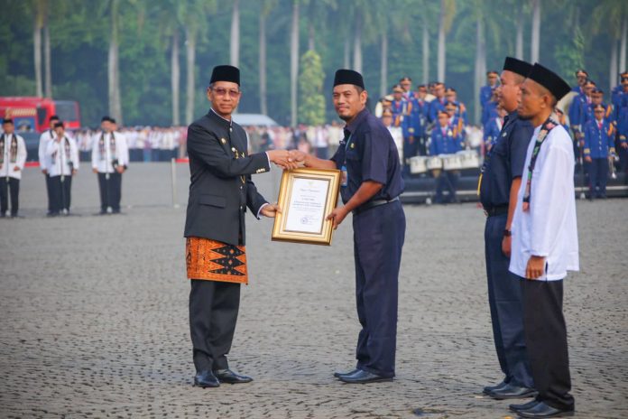 Pj Gubernur DKI Heru Budi Hartono memberikan penghargaan kepada tenaga pendidik saat memperingati Hardiknas di Silang Monas, Jakarta, Selasa (2/5/2023).