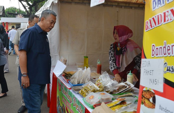 Ketua DPRD DKI Prasetyo Edi Marsudi membeli ikan bandeng presto di Bazar UMKM yang digelar di halaman gedung DPRD DKI Jakarta.