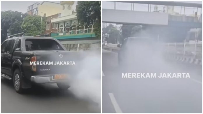 Tangkapan layar mobil pelat merah mengeluarkan asap saat melintas di kawasan Mampang, Jaksel.