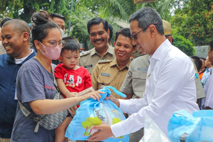 Pj Gubernur DKI Jakarta Heru Budi Hartono mengecek paket sembako murah yang digelar Dinas KPKP DKI di Gunung Sahari, Jakarta Pusat, Senin (21/1/2024).