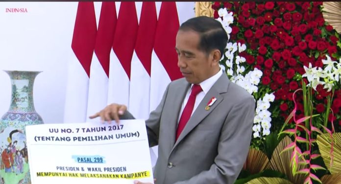 Presiden Jokowi menujukkan bukti pasal dalam UU Presiden dan Wakil Presiden boleh kampanye, Jumat (26/1/2024).