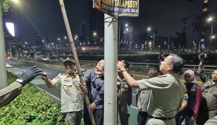 Wali Kota Jakarta Selatan Munjirin menurunkan APK Pemilu di Jalan Gatot Subroto, Jakarta Selatan, pada Minggu (11/2/2024) dinihari.