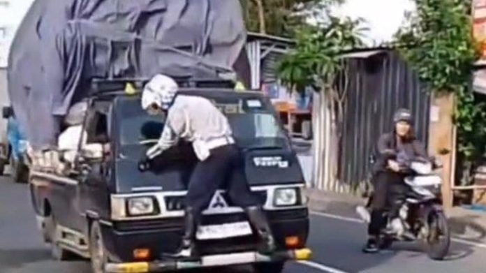 Tangkapan layar video saat anggota Dishub Depok bergelantungan di kap mobil barang.