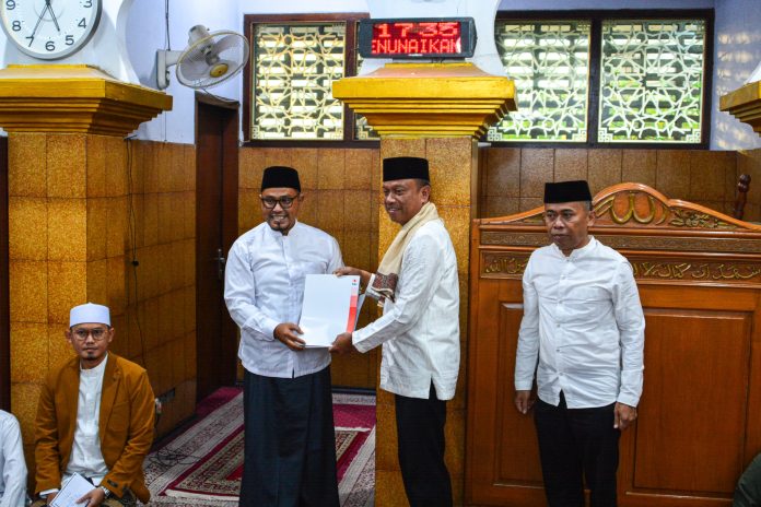 Wali Kota Jaksel Munjirin didampingi Camat Cilandak Djahrudin saat menyerahkan bantuan dana sosial kepada pengurus masjid Al-Ihsan dalam rangka Safari Ramdahan 1446 H dan buka puasa bersama, Jumat (14/3/2025) malam.