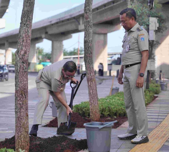 Gubernur Jakarta Pramono Anung didampingi Wali Kota Jakarta Timur menanam pohon di kawasan industri Cakung, Selasa (27/5/2025).