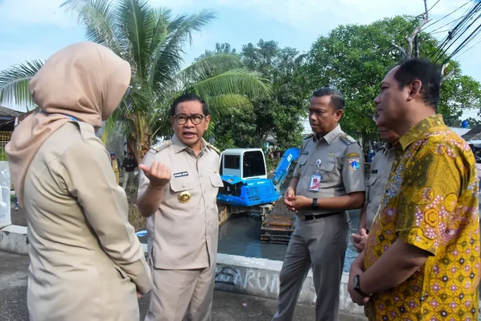 Gubernur Jakarta Pramono Anung bersama Wali Kota Jaktim Munjirin dan Kepala Dinas (Kadis) SDA DKI Jakarta Ika Agustin saat meninjau langsung pengerukan Kali Irigasi Bekasi Ujung Menteng, di Jalan Irigasi, Kelurahan Ujung Menteng, Kecamatan Cakung, Jakarta Timur, Senin (7/7/2025).