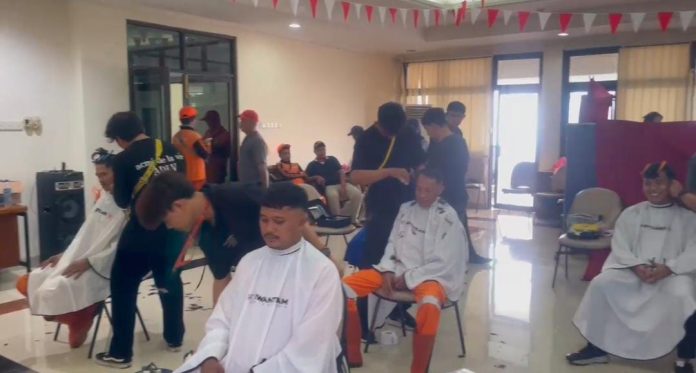 Para petugas Penanganan Prasarana dan Sarana Umum (PPSU) saat menikmati layanan potong rambut gratis di Kantor Kelurahan Pejaten Timur, Pasar Minggu, Jakarta Selatan, Kamis (7/8/2025).