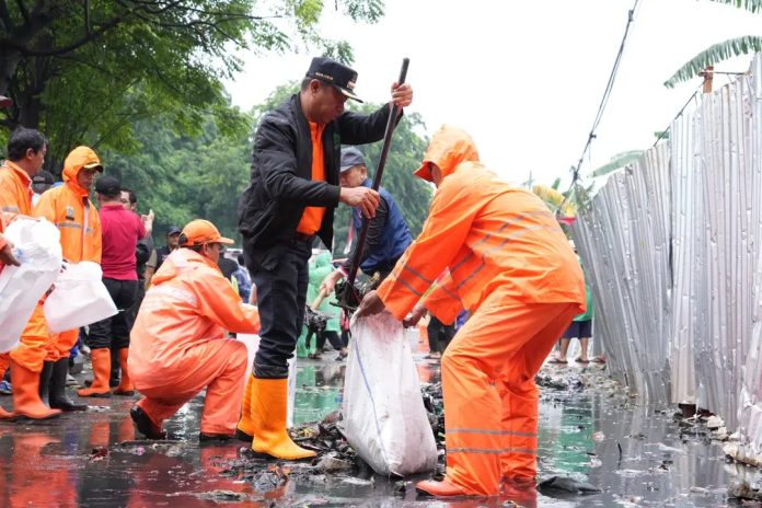 Wali Kota Kota Administrasi Jakarta Timur Munjirin angkat pacul saat Aksi Kebersihan Minggu Pagi (AKMP) di eks lahan Tempat Penampungan Sementara (TPS) sampah Rusunawa PIK, Kelurahan Penggilingan, Kecamatan Cakung, Minggu (18/1/2026).