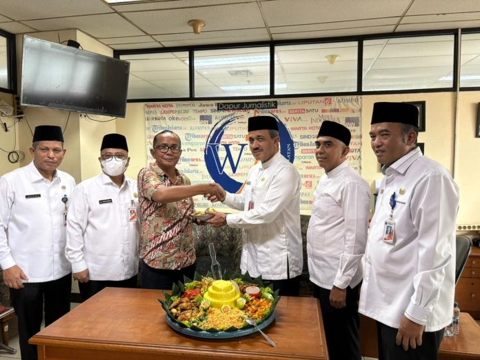 Wali Kota Jakarta Selatan M Anwar didampingi Wakil Wali Kota Ali Murtadho, Sekretaris Kota Administrasi Muklisin, Asisten Perekonomian dan Pembangunan Sayid Ali, serta Asisten Kesejahteraan Rakyat Tomy Fudihartono menyerahkan potongan tumpeng kepada Ketua WJS Robin Tarigan dalam rangka HPN 2026, Jumat (13/2/2026).