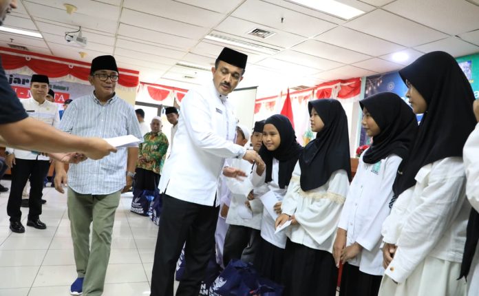 Wali Kota Jakarta Selatan Muhammad Anwar didampingi Ketua WJS Roebin Tarigan menyerahkan santunan kepada anak yatim di ruang Nusantara, Kantor Waliko Jakarta Selatan, Jumat (13/3/2026).
