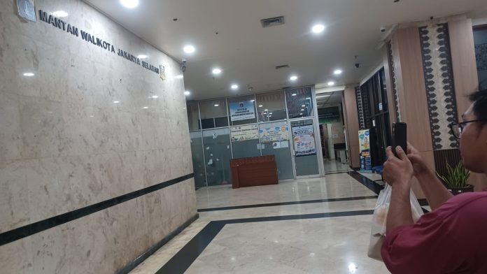 Warga bernama Isa Bustomi memotret dinding lobi kantor Wali Kota Jakarta Selatan yang tampak kosong tanpa hiasan foto-foto mantan wali kota.