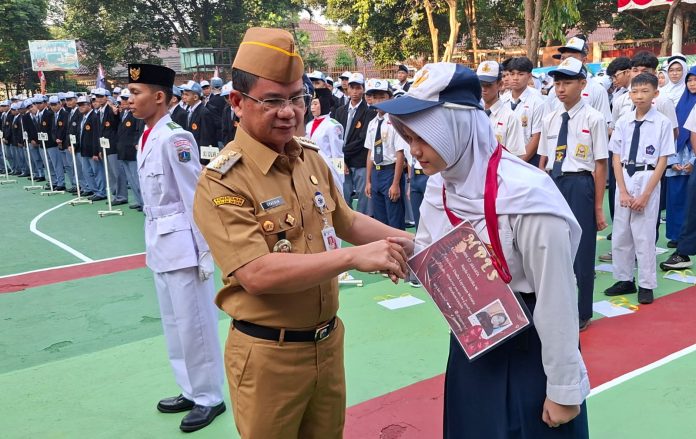 Wali Kota Jaksel Syafrin Liputo menyematkan tanda pengenal MPLS kepada siswa SMKN 57, Jakarta, di hari pertama sekolah, Senin (13/7/2026).
