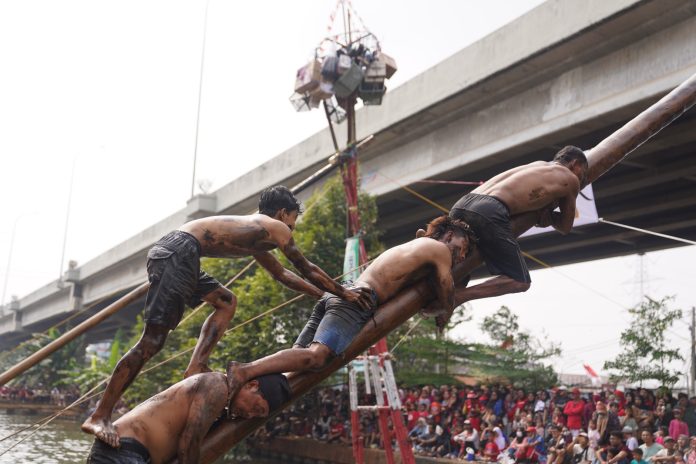 Lomba panjat pinang di Kali Malang, Jakarta Timur, Senin (17/8/2026).