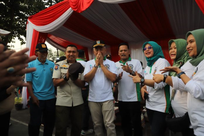 Momen Sekretaris Kota Jakarta Selatan Muklisin saat dihampiri oleh Sekcam Pesanggrahan Martin Sunardi dan Anggota Satpol PP Puji Waluyo usai apel kerja bakti, Mingu (9/8/2026).